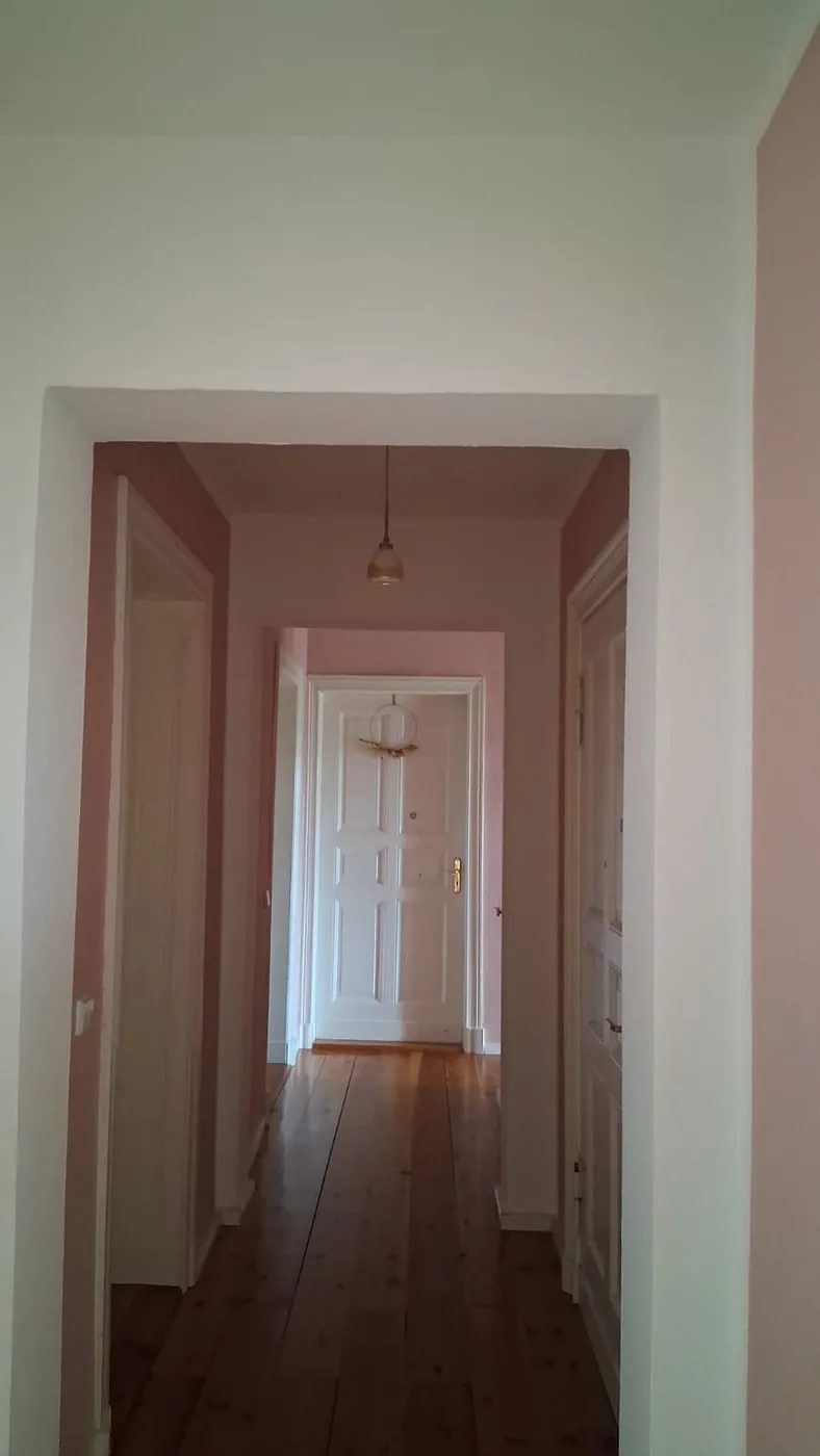 Renovierter Altbauflur in zartem Rosé mit Dielenboden