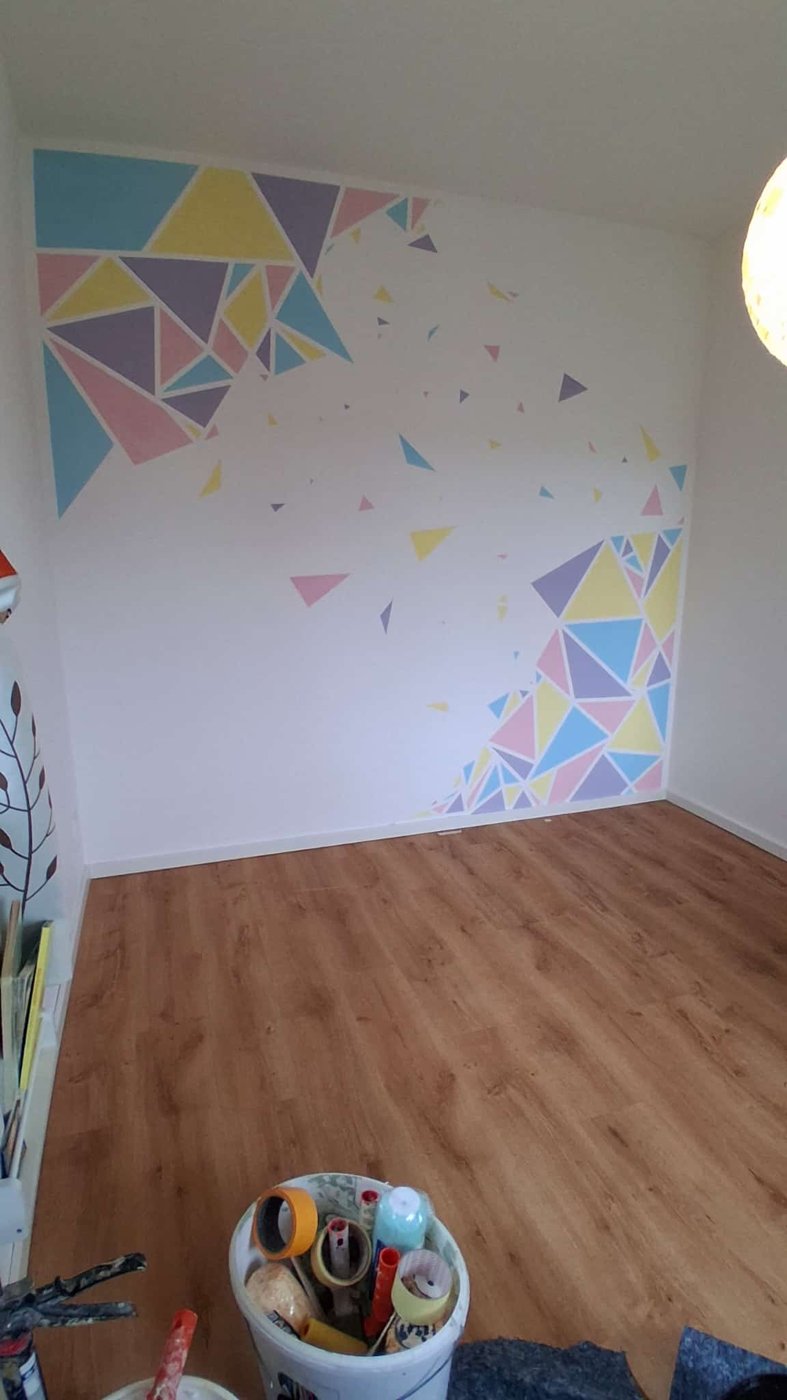 Kinderzimmer Wand mit geometrischen Dreiecken in Pastellblau, Gelb, Rosa und Flieder